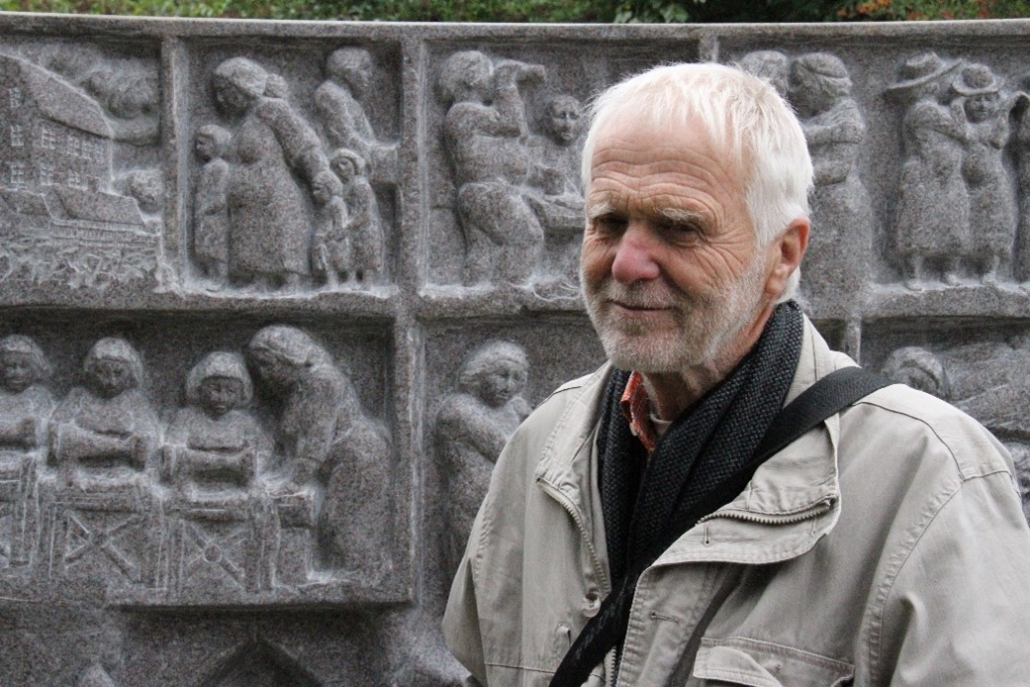 Skulptören Sam Westerholm framför minnesstenen över Maria Sandel